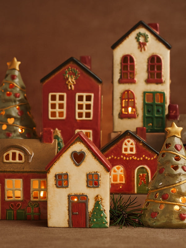 THATCH Living decorative Christmas tealight houses with lit windows and trees on a brown background by THATCH Living.