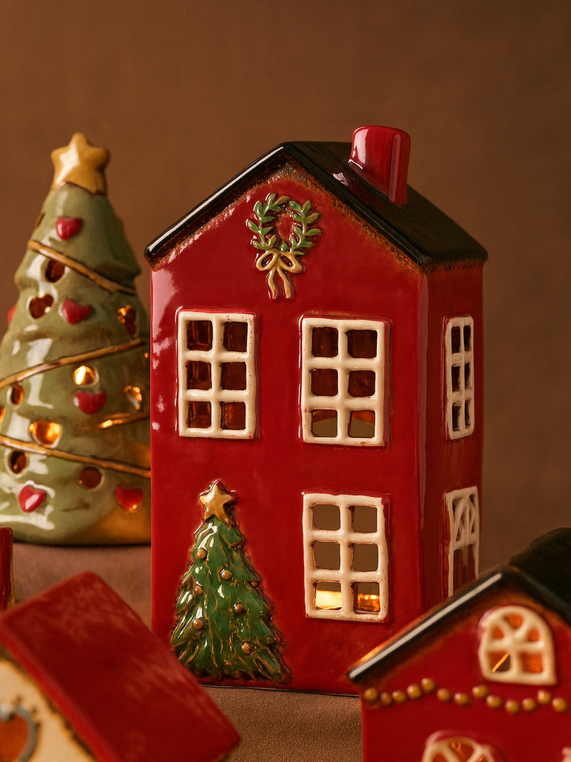 THATCH Living decorative red ceramic house-shaped candle lantern with Christmas tree and wreath on a brown background by THATCH Living.
