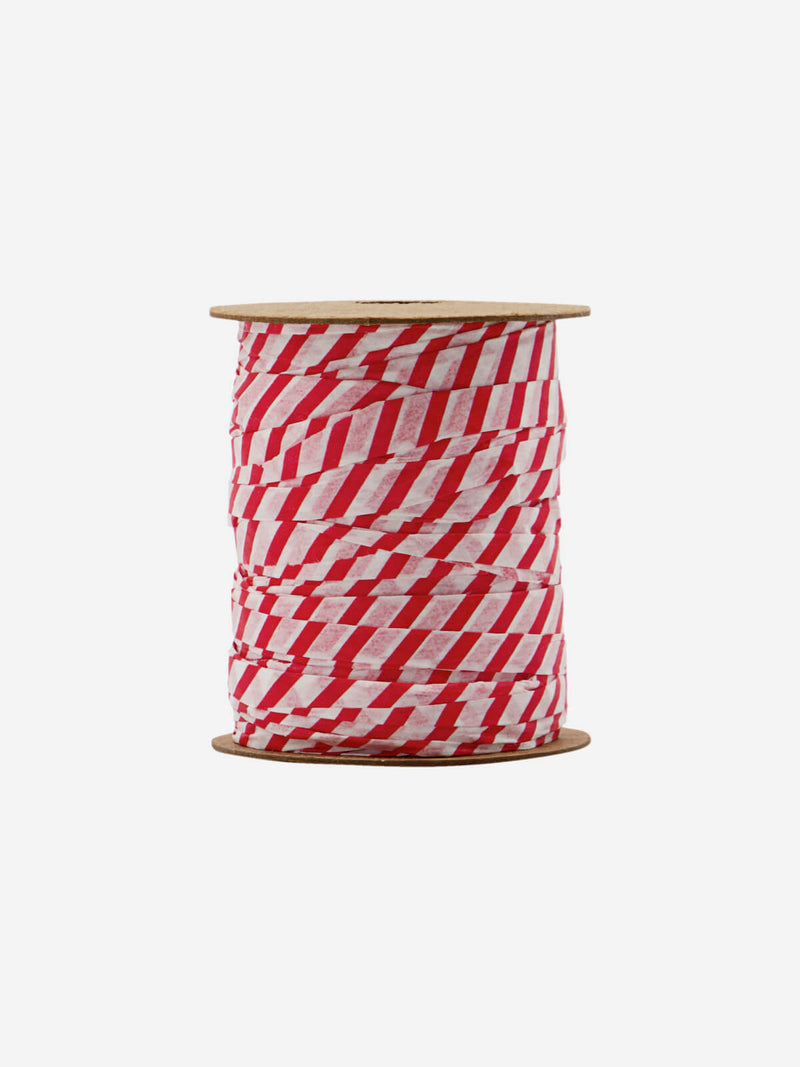 Bobbin of paper ribbon in white red candy cane festive decor.
