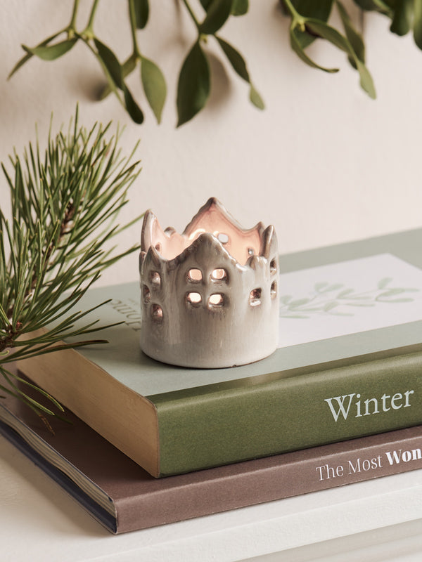 Ceramic house candle tealight holder in white by THATCH Living on a book with greenery