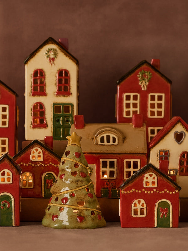 THATCH Living Decorative ceramic houses tealight holder and a Christmas tree tealight holder on a brown background - by THATCH Living.