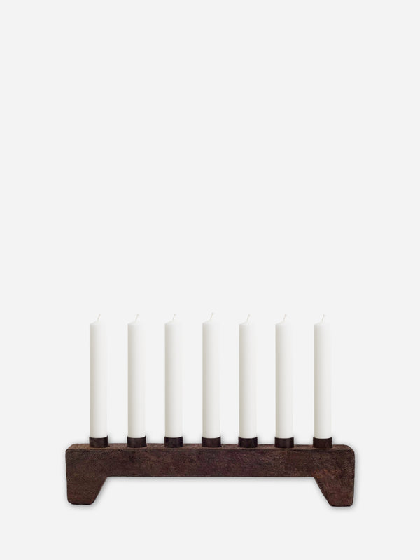 Wooden Candle holder from THATCH Living with seven white candles on a white background