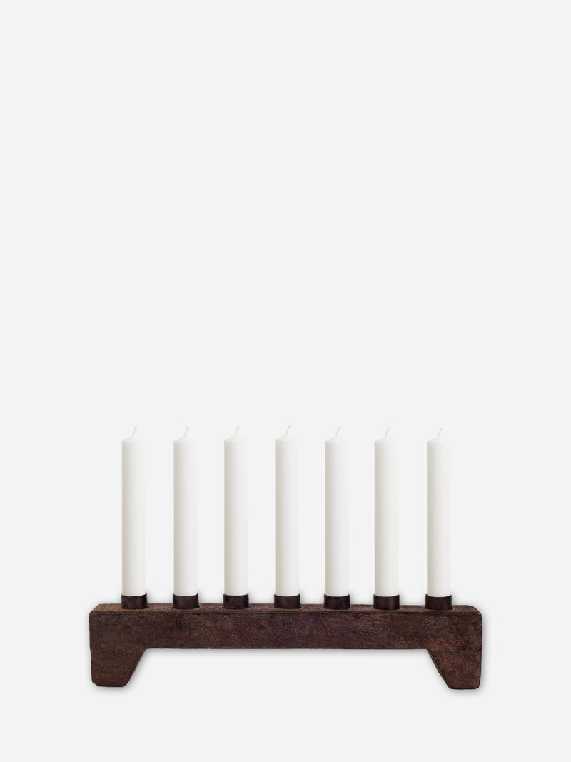 Wooden Candle holder from THATCH Living with seven white candles on a white background