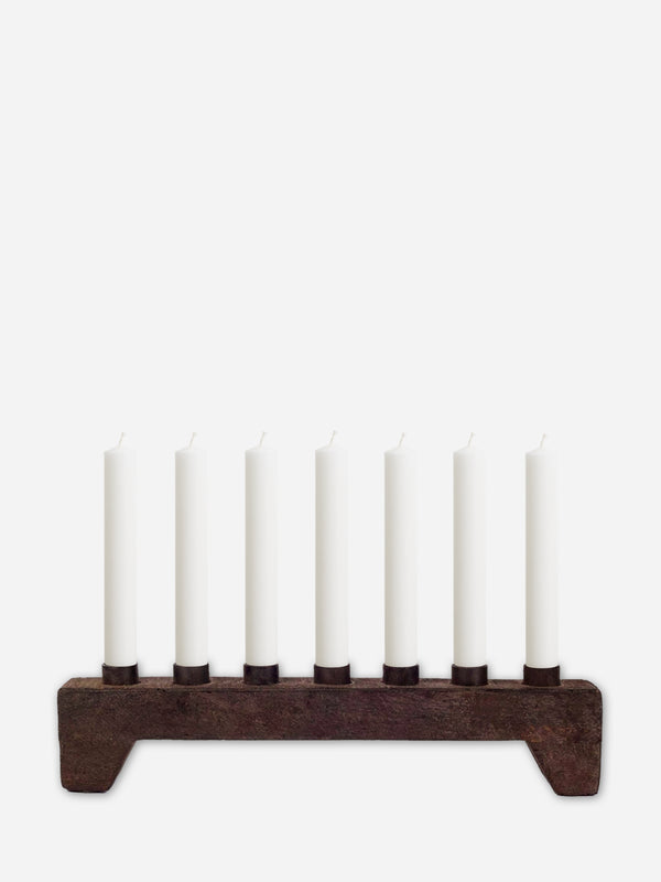 Wooden Candle holder from THATCH Living with seven white candles on a white background
