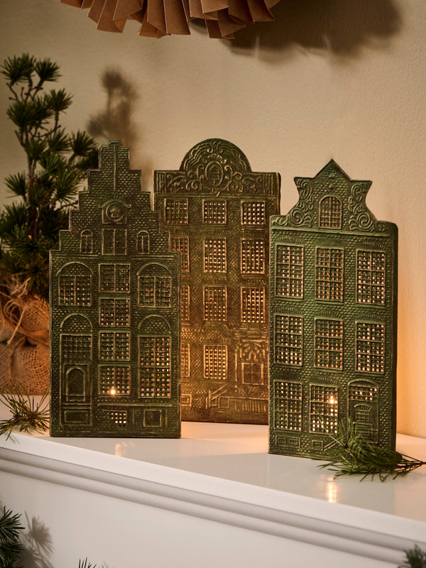 Decorative candle holders by THATCH Living shaped like Canal houses on a white surface with a neutral background