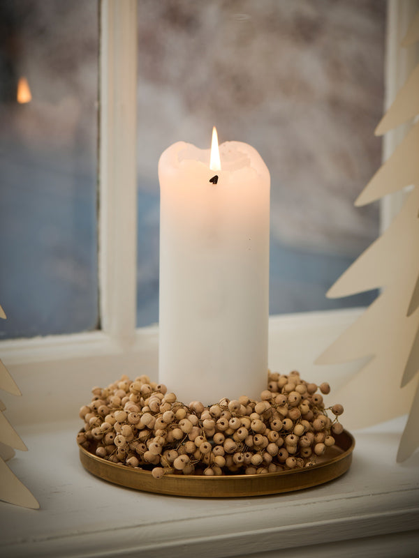 Natural Wooden Beaded Berry Wreath Small on windowsill, lit white pillar candle, brass tray, mooddy lighting, snow, Christmas decor.