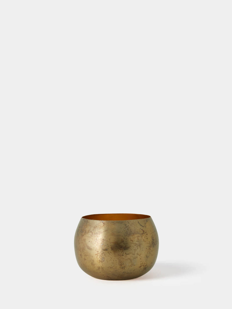 Brass tealight holder, made from metal, white background.