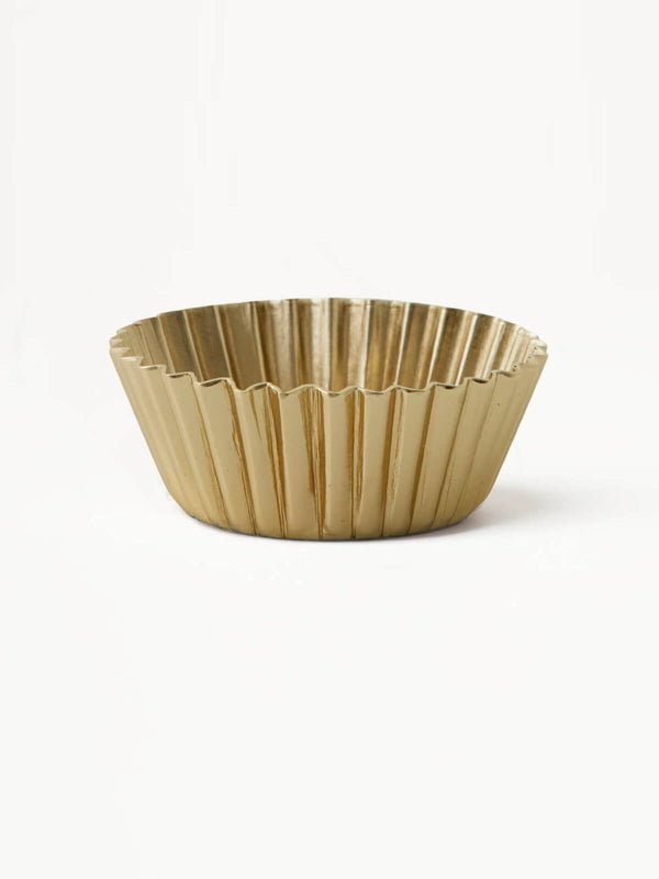 Closeup of gold tealight holder in white background.