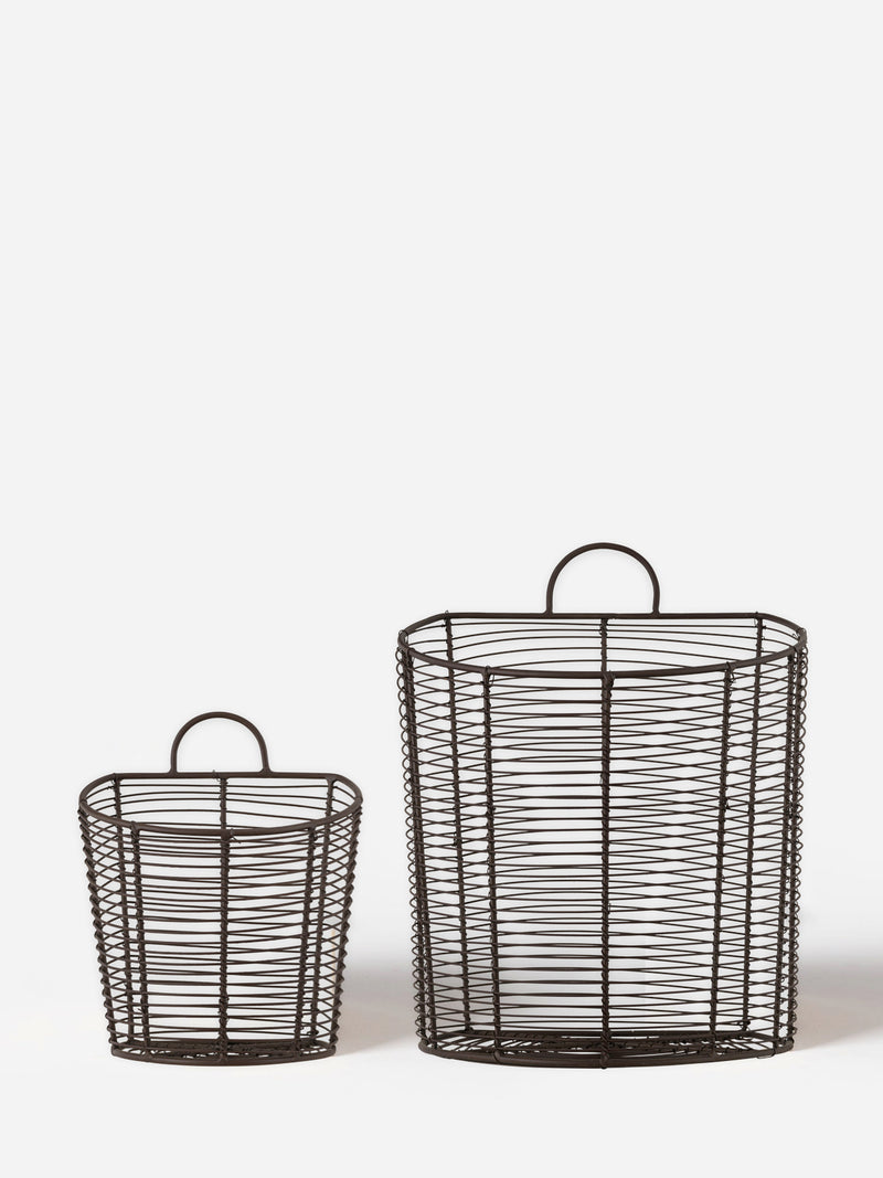 A set of two aged brass bronze wire baskets by THATCH Living with handles on a white background.