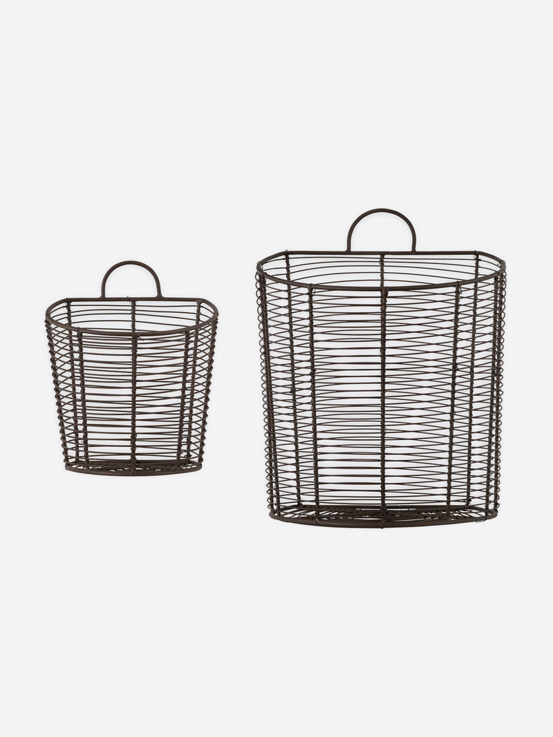 A set of two aged brass bronze wire baskets by THATCH Living with handles on a white background.