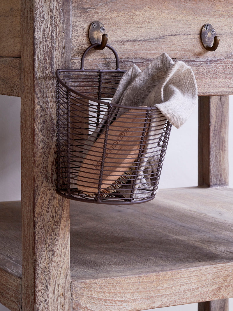 Wire basket by THATCH Living with a towel hanging on a wooden surface