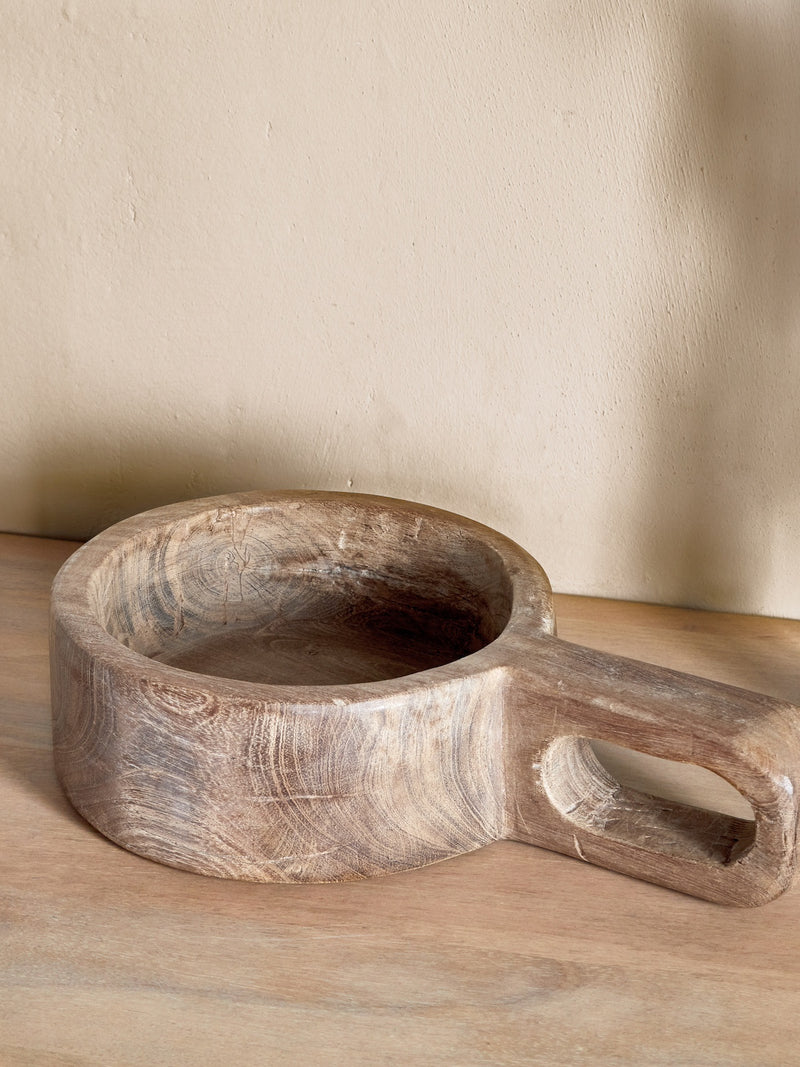 Wooden bowl with handle on a wooden surface natural decor