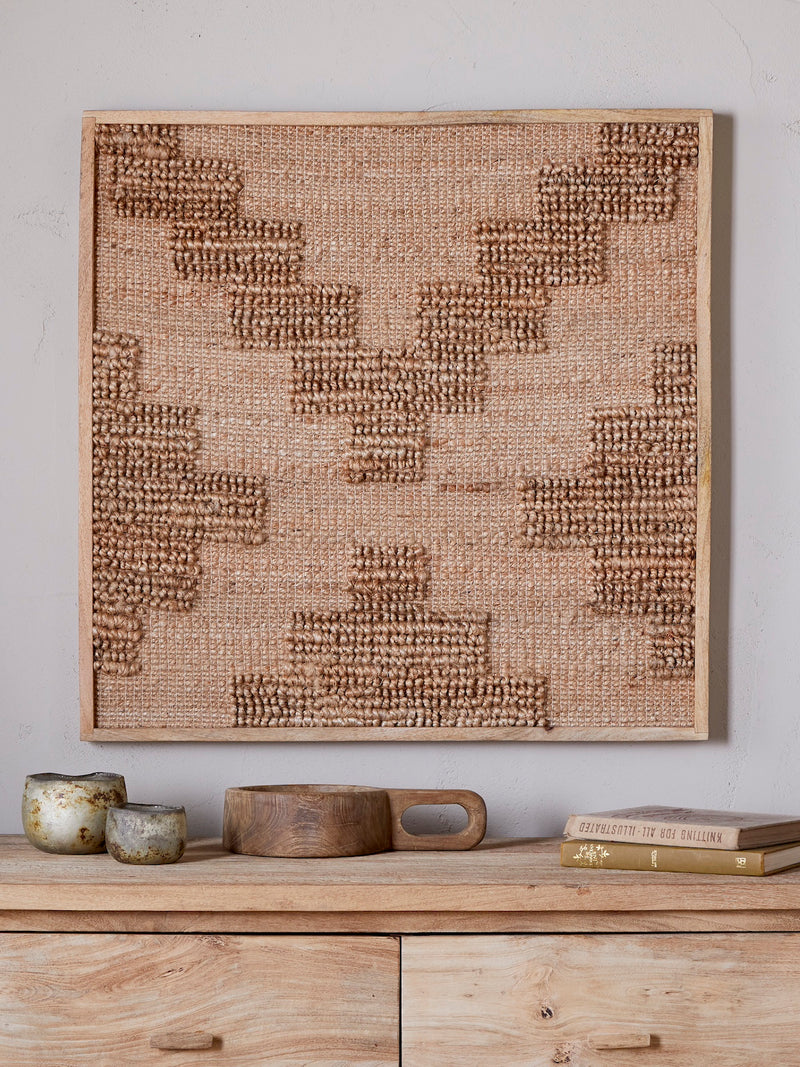 Textured wall art piece on a wooden shelf with reclaimed wood decorative wooden bowl.