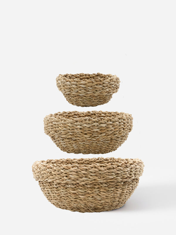 Set of three natural woven seagrass baskets in varying sizes, stacked vertically.