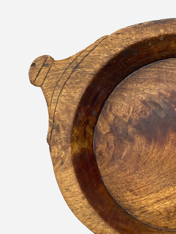Close-up of a wooden bowl with a textured surface on a light gray background by THATCH Living.