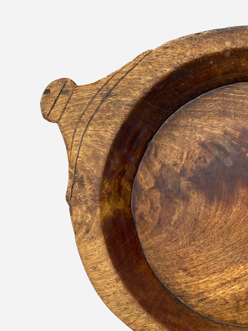 Close-up of a wooden bowl with a textured surface on a light gray background by THATCH Living.