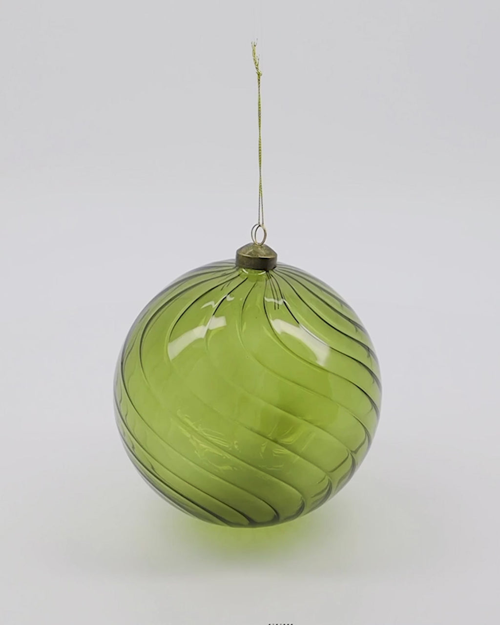 A 360 degree video of a green Christmas bauble made from glass.
