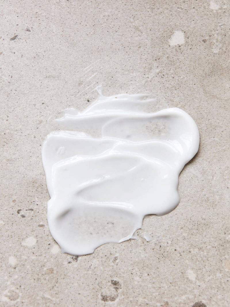 A sample of Meraki silky mist hand lotion spread on marble worktop.