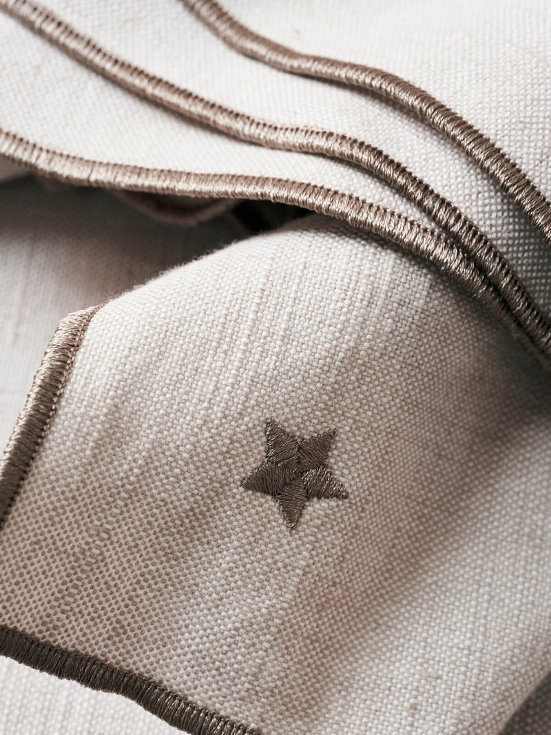 Cotton napkin in beige with embroidered stars.