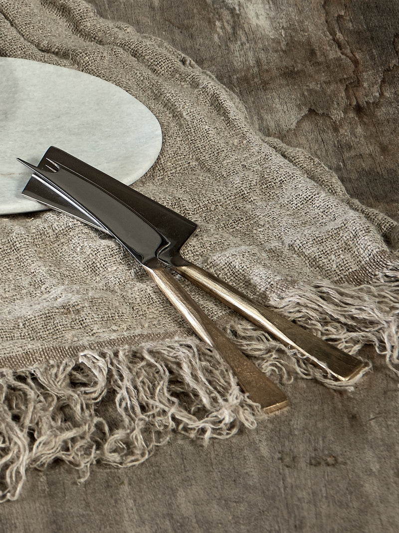Cheese and Knife set of 2 by THATCH Living on a oak rustic table on top of white plate and linen napkins.