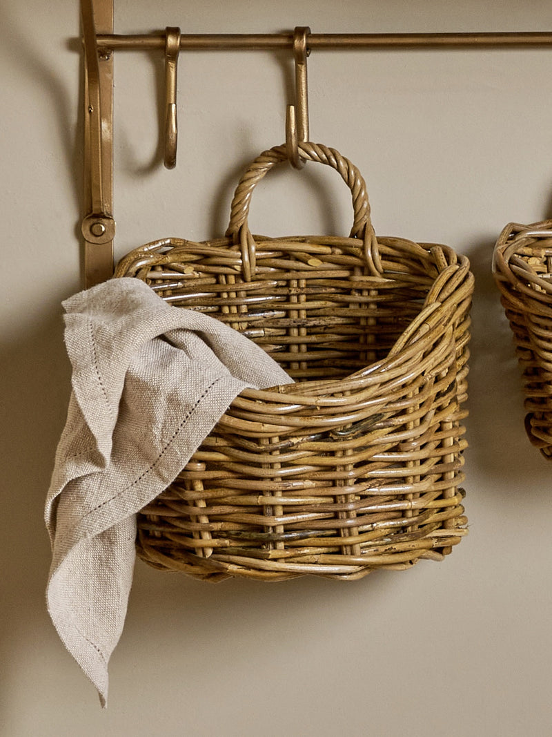 A THATCH Living wall hung wicker basket with a towel hanging on a wall-mounted hook