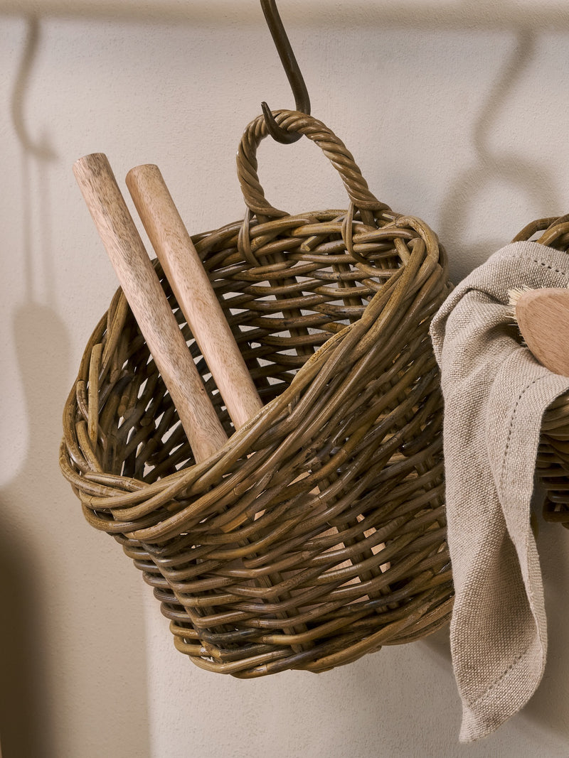 A THATCH Living wall hung Wicker basket with wooden sticks and a towel hanging on a wall.