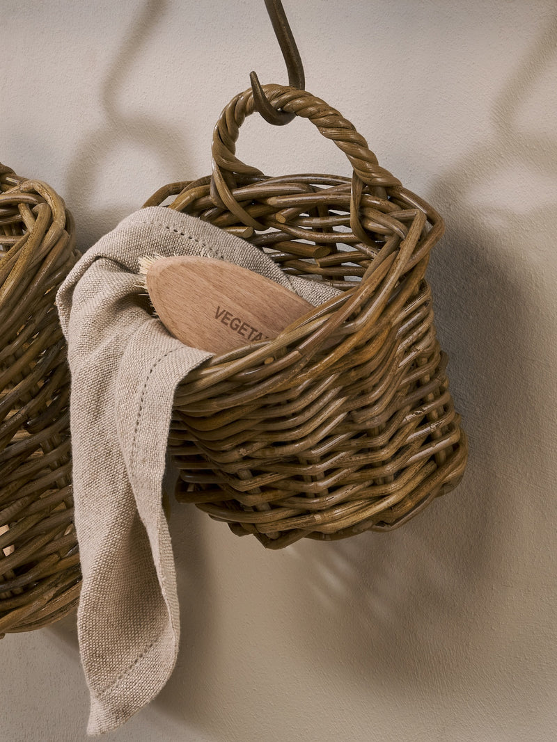 Woven rattan baskets by THATCH Living hanging against a neutral background