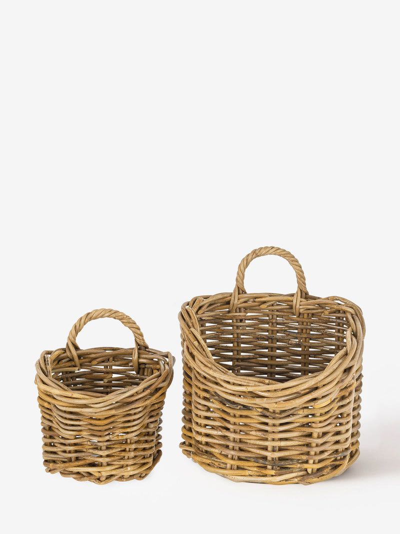 A set of Two wicker baskets by THATCH Living with handles on a white background