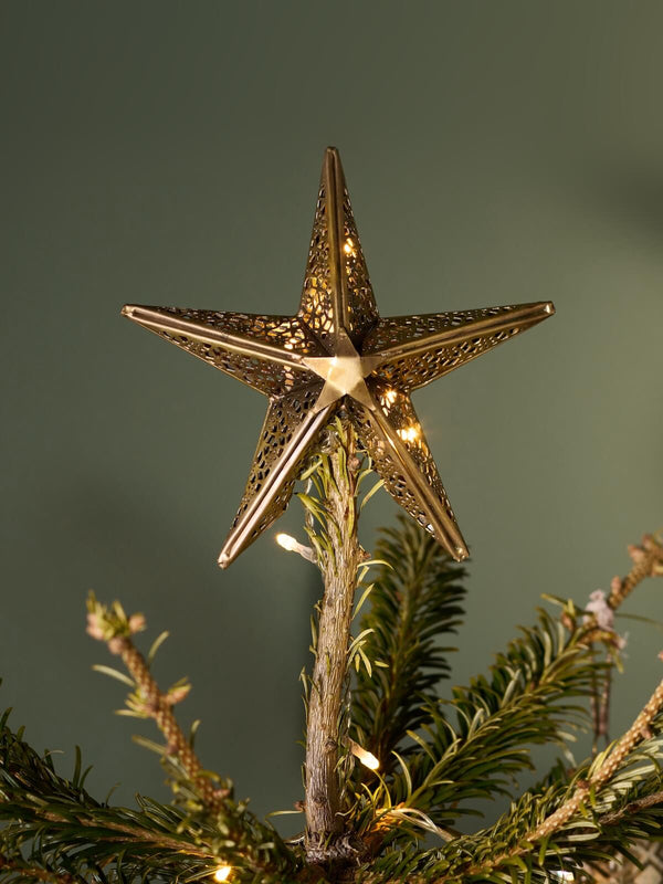 Brass star tree topper on Christmas tree